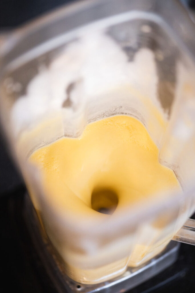blending mango and coconut milk in a blender